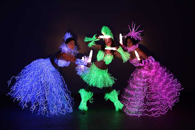 Blacklight shows with three performance artists wearing glow in the dark costumes
